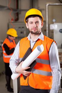 stock image of architect with plans and hi-vis jacket