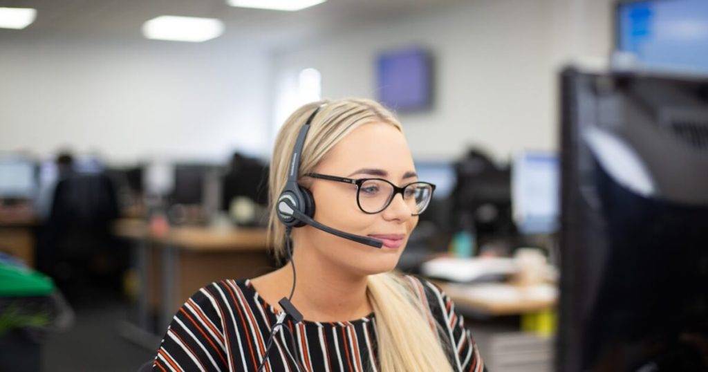 Customer research call handler at Insight Data office wearing headset