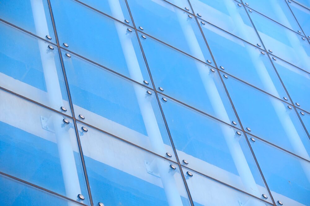 Curtain walling fenestration with reflective glass panels and steel fixings